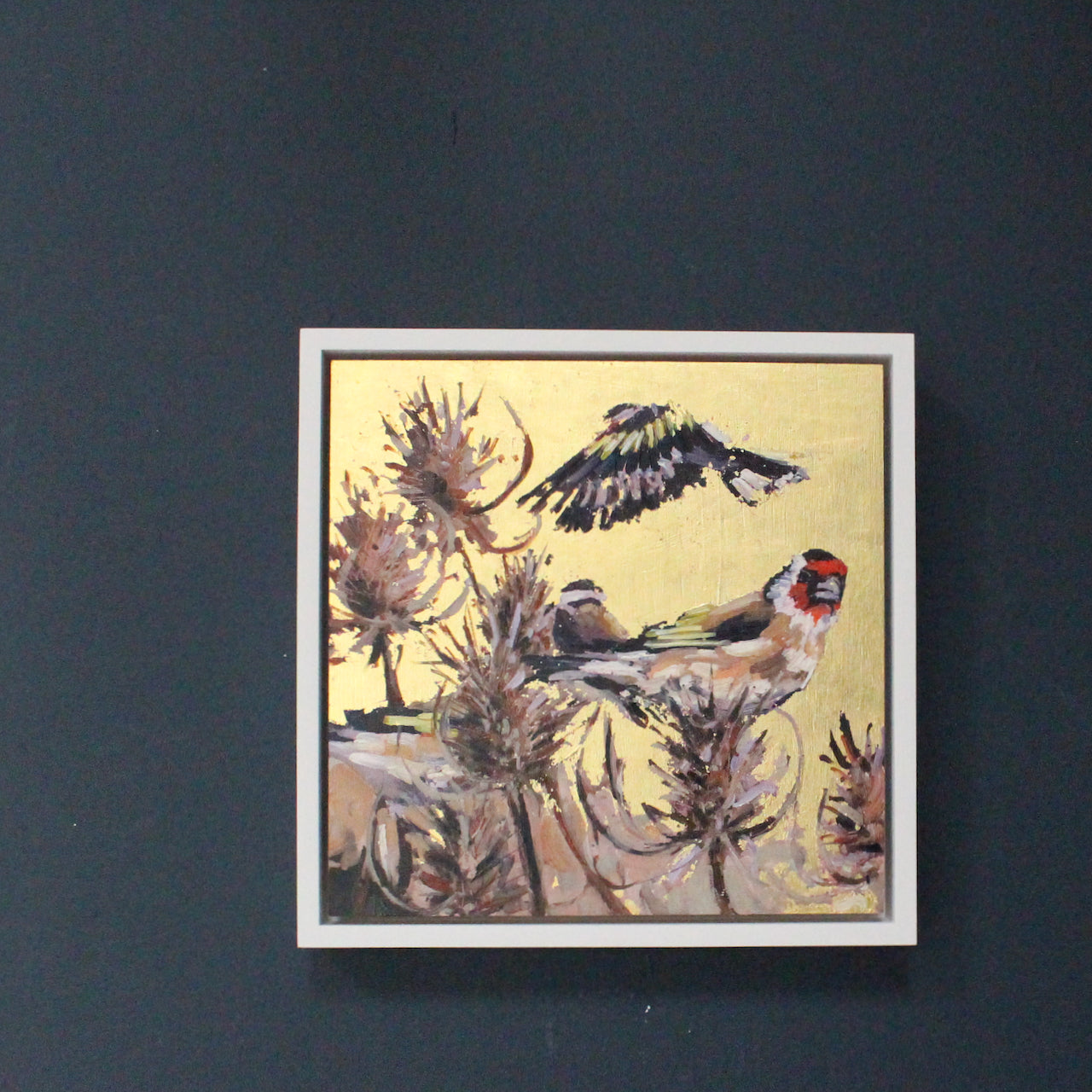 Artist Jill Hudson framed gold lustre square painting with three goldfinch birds and thistles.