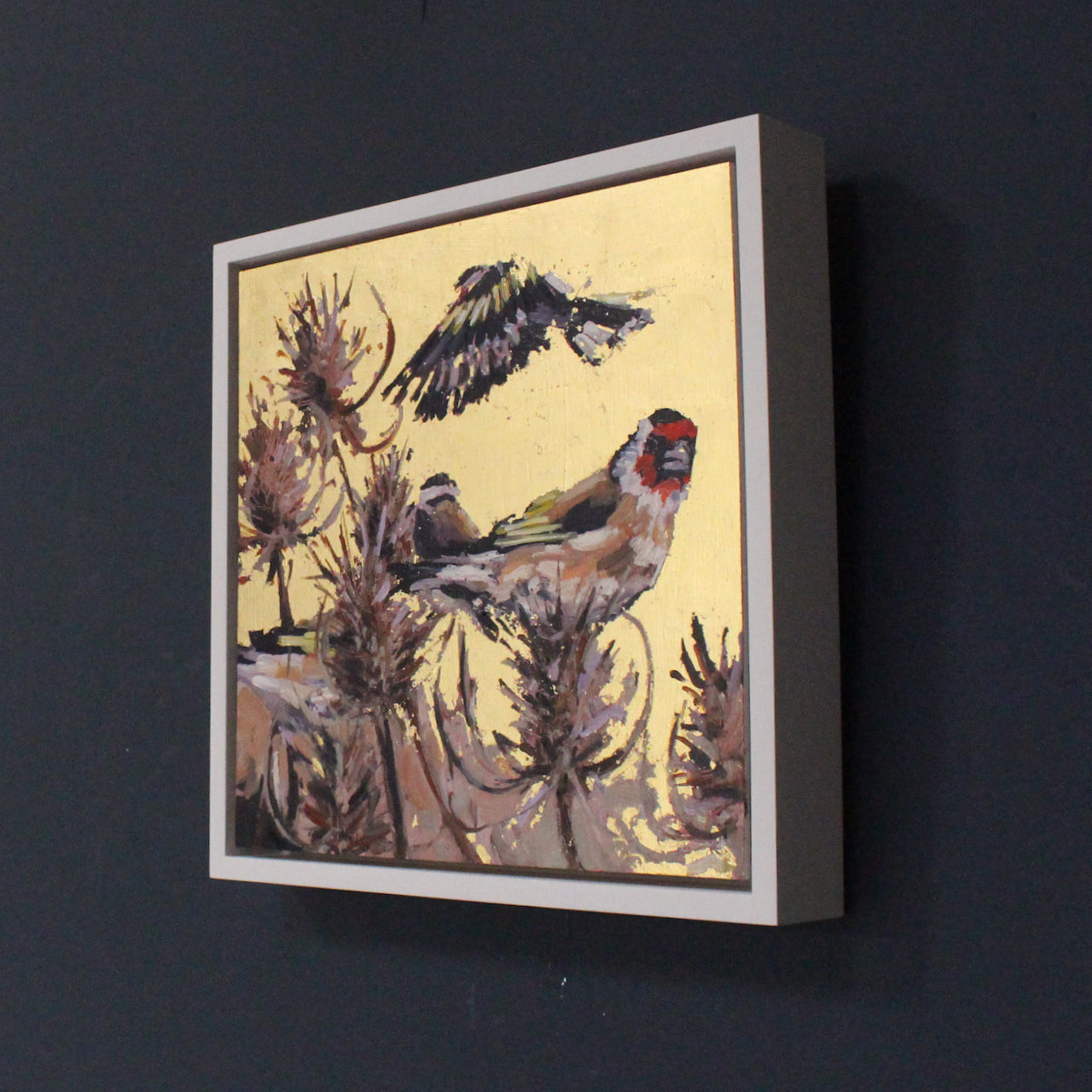 Framed gold lustre square painting with three goldfinch birds and thistles by artist Jill Hudson.