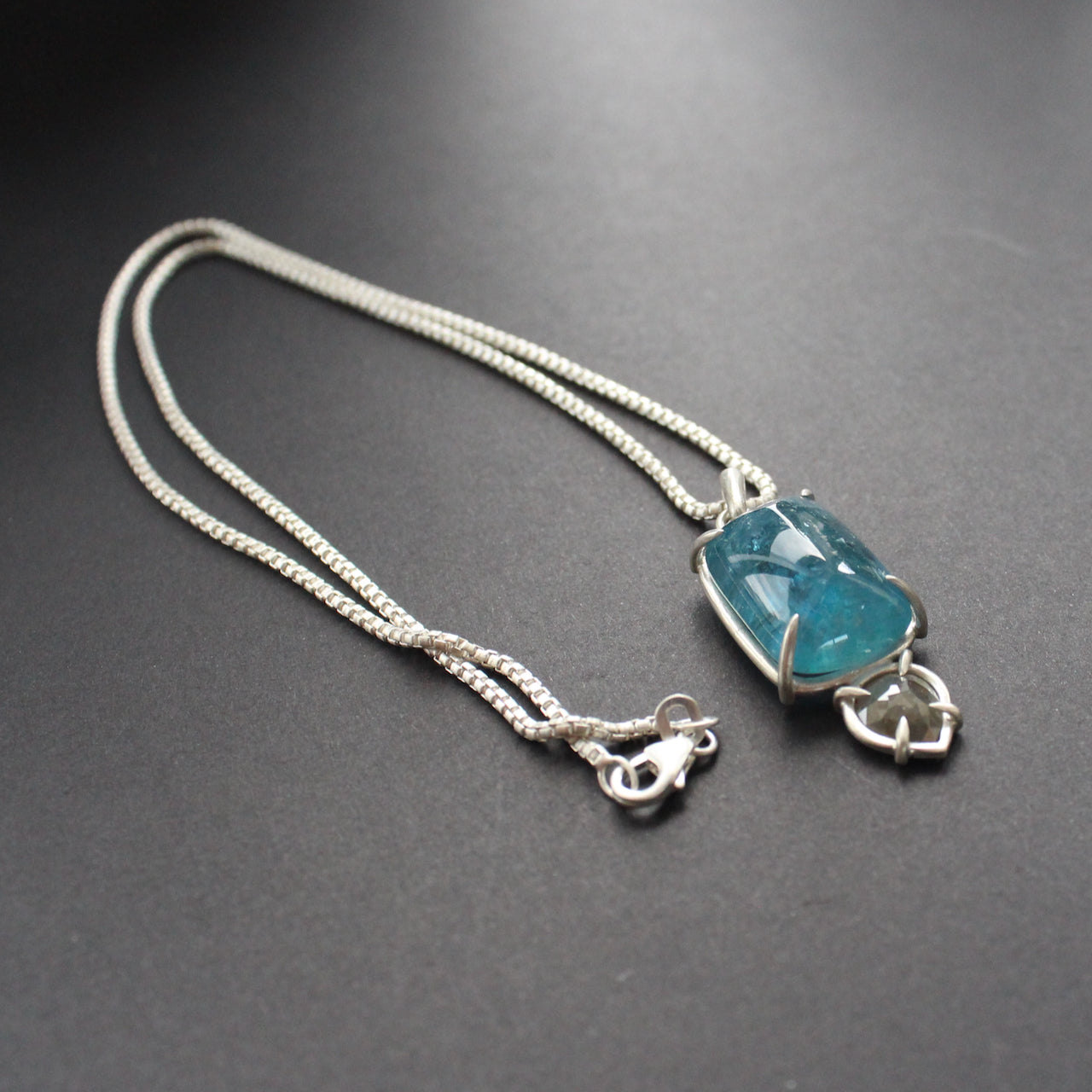 a pendant with large blue aquamarine and small diamond in a silver setting  by Cornwall jeweller Carin Lindberg