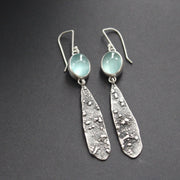 a pair of Carin Lindberg long lozenge shaped textured silver earrings with pale blue aquamarine stone setting