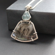 striking pendant by jewellery designer Carin Lindberg featuring small pale blue stone above a grey and detailed agate stone in a silver setting