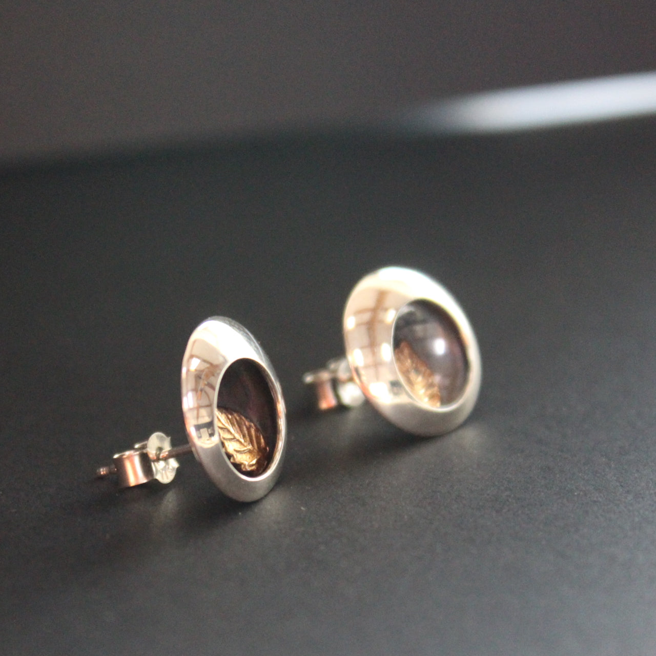 Round silver stud earrings with leaf inlay by UK artist Beverly Bartlett.