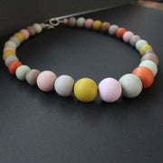 Graduated size round beaded necklace in muted earth tones by UK artist Clare Lloyd