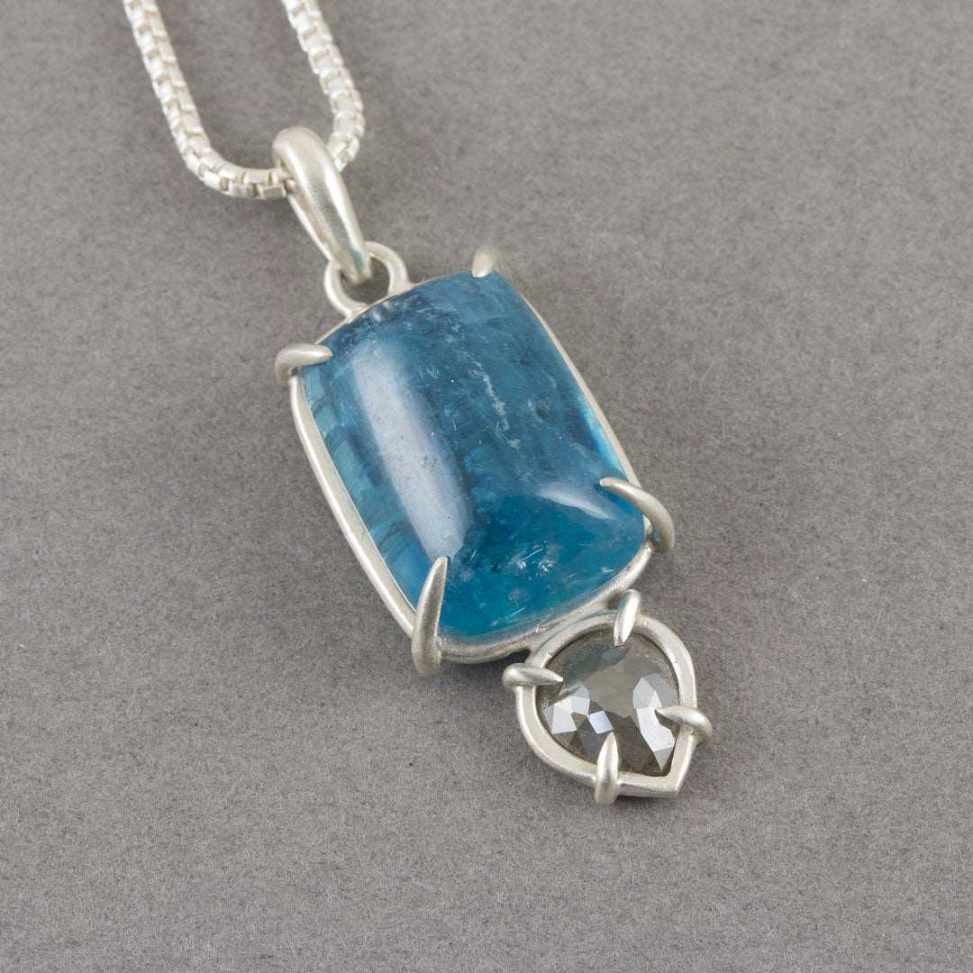 a Carin Lindberg pendant with large blue aquamarine and small diamond in a silver setting.