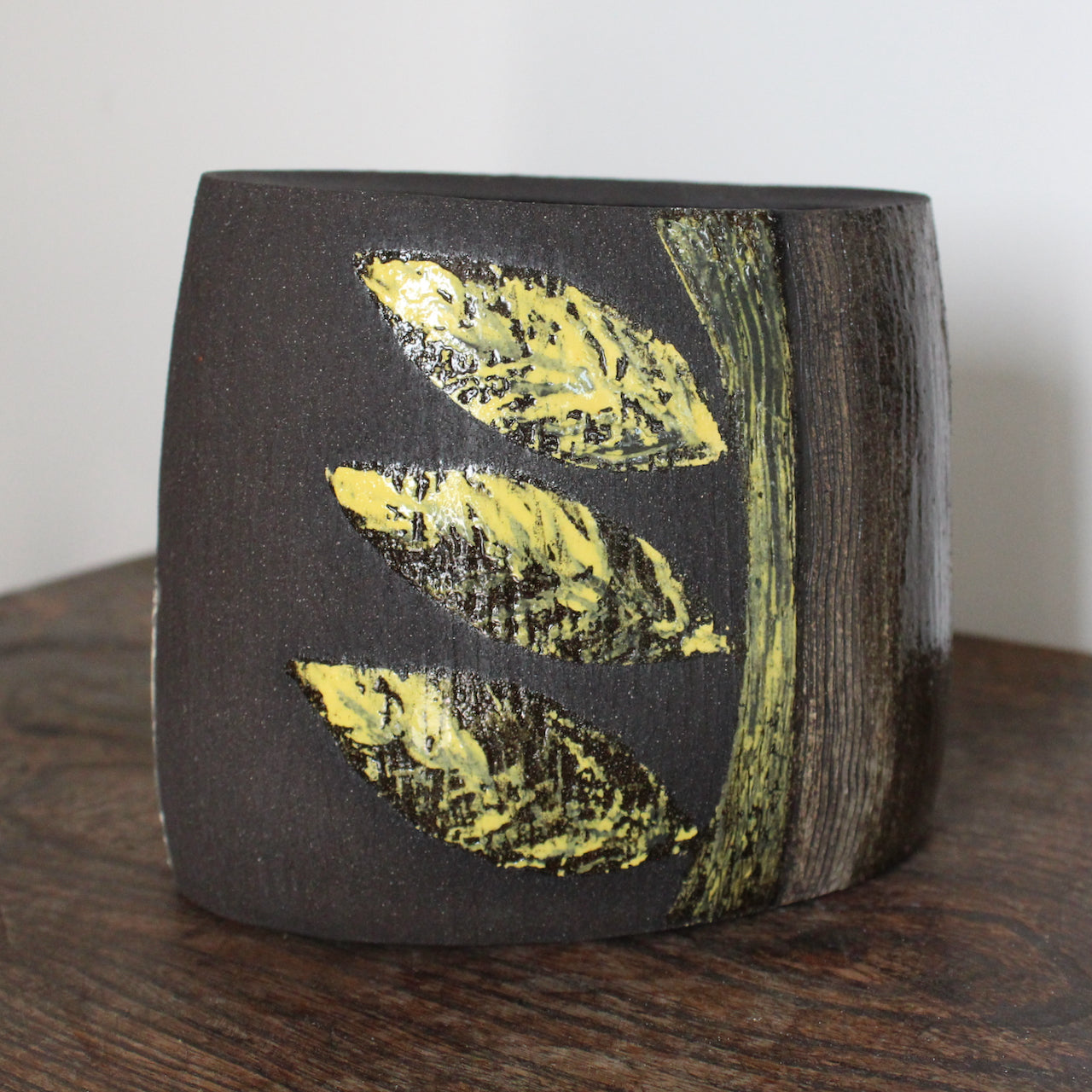 Ceramic vessel with yellow leaf shaped glaze on dark brown clay by Cornish Artist Anthea Bowen
