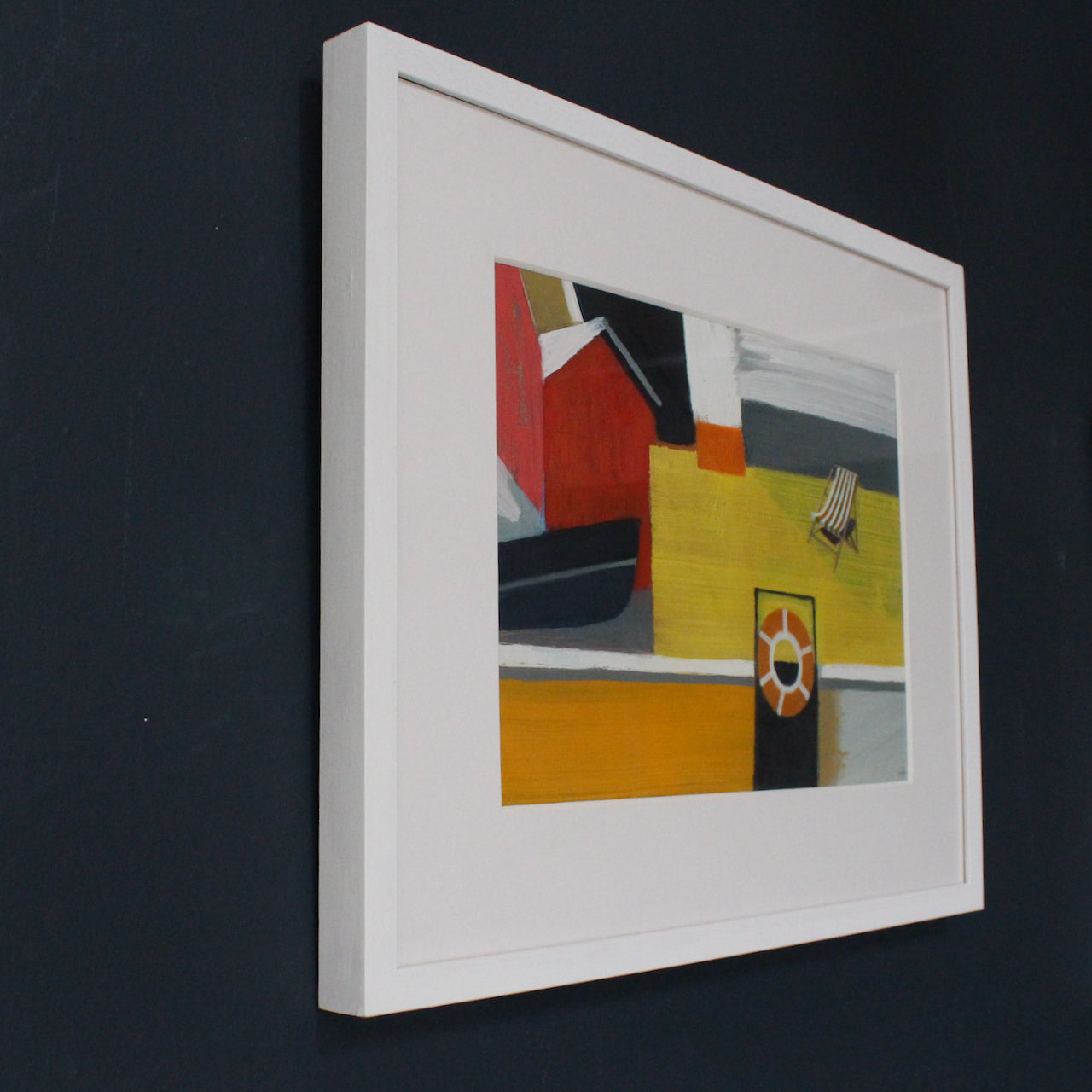 framed painting by Cornwall artist Heath Hearn of a stripy deckchair on a yellow painted boat with an orange rubber ring in the foreground