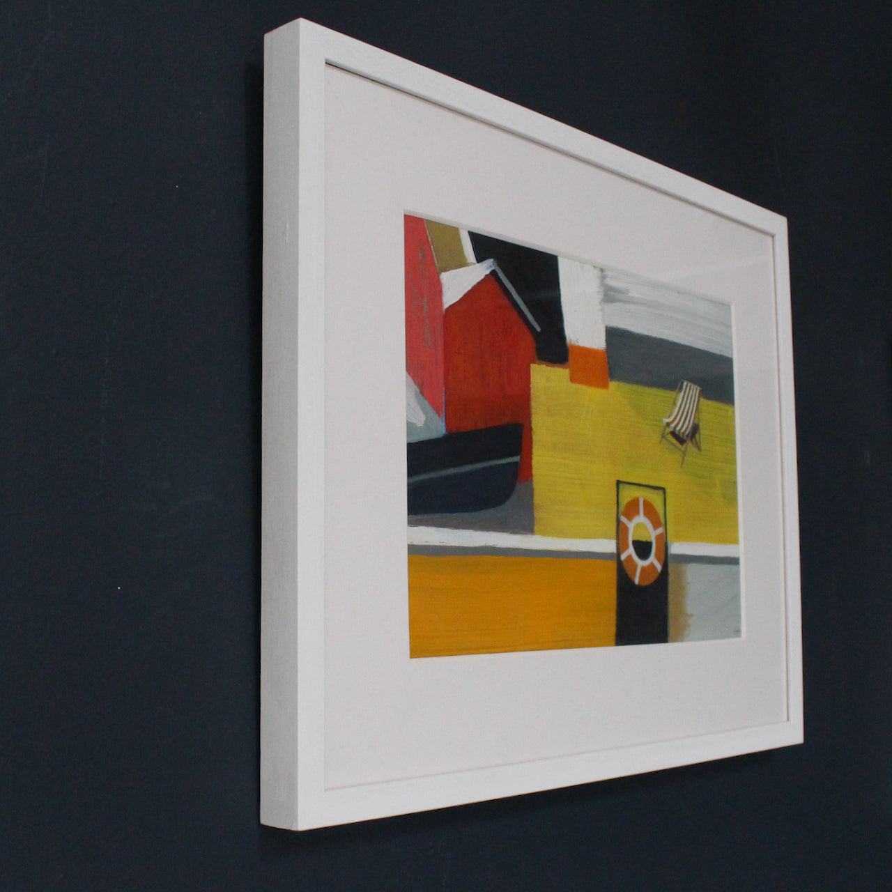 framed painting by Cornwall artist Heath Hearn of a stripy deckchair on a yellow painted boat with an orange rubber ring in the foreground 