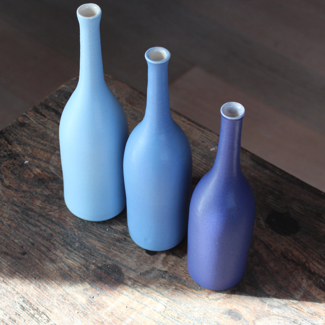three  ceramic bottles in shades of blue by UK ceramicist Lucy Burley