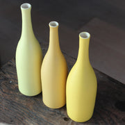 three ceramic bottles in shades of yellow by UK ceramic artist Lucy Burley.