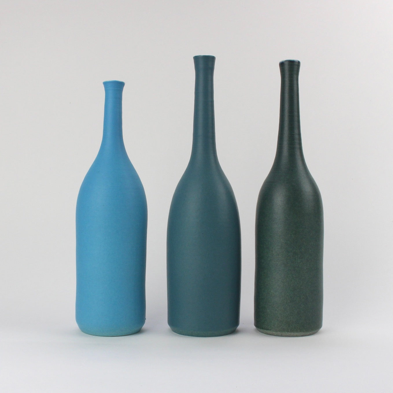 a trio of  ceramic bottles in shades of teal and blue by UK ceramicist Lucy Burley.