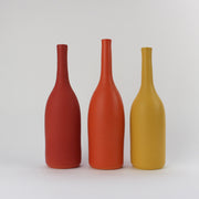 Three elegant ceramic bottles in shades of yellow and orange by UK ceramicist Lucy Burley.