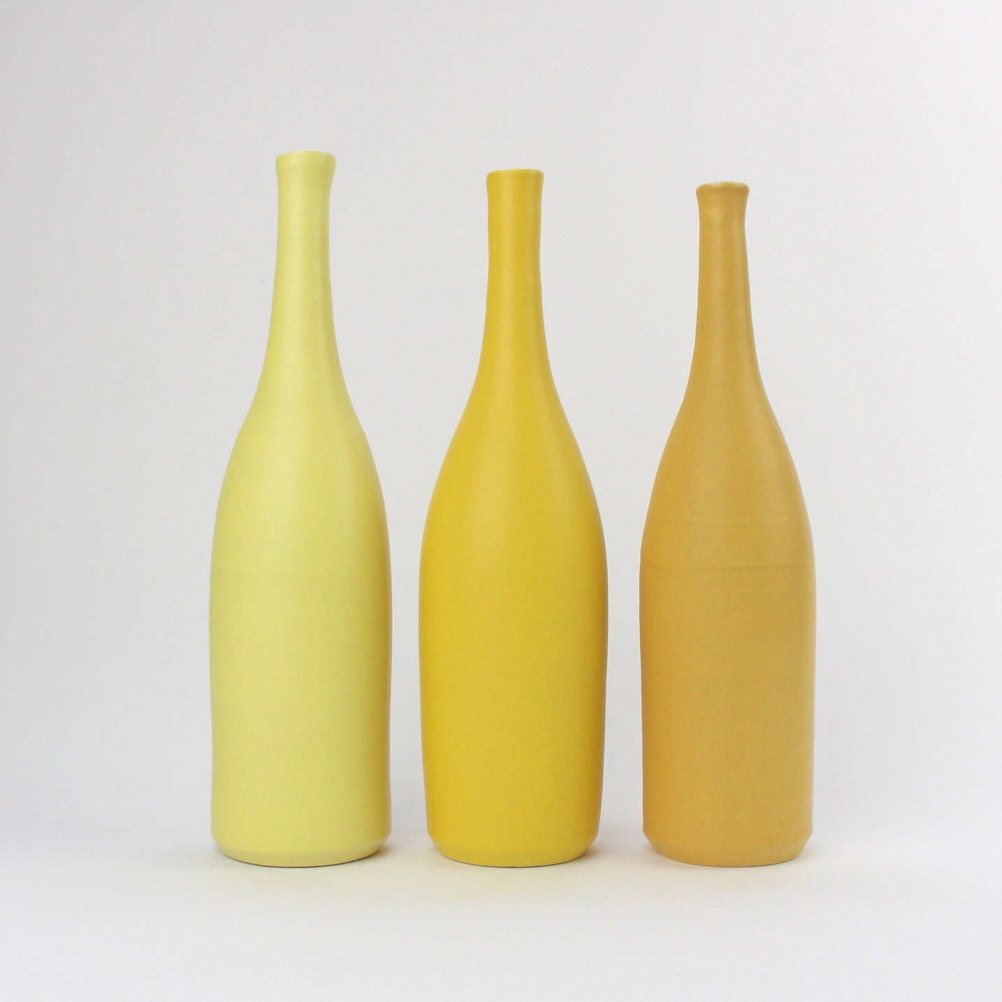 a trio of  ceramic bottles in shades of yellow by UK ceramicist Lucy Burley