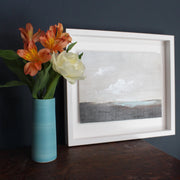 Cornish artist Nicola Mosley, Seascape of dark shore with blue sea and white clouds