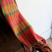 detail of a Teresa Dunne handwoven scarf in pinks, green, reds and yellows