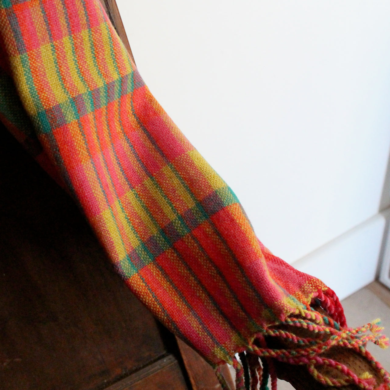 detail of a Teresa Dunne handwoven scarf in pinks, green, reds and yellows