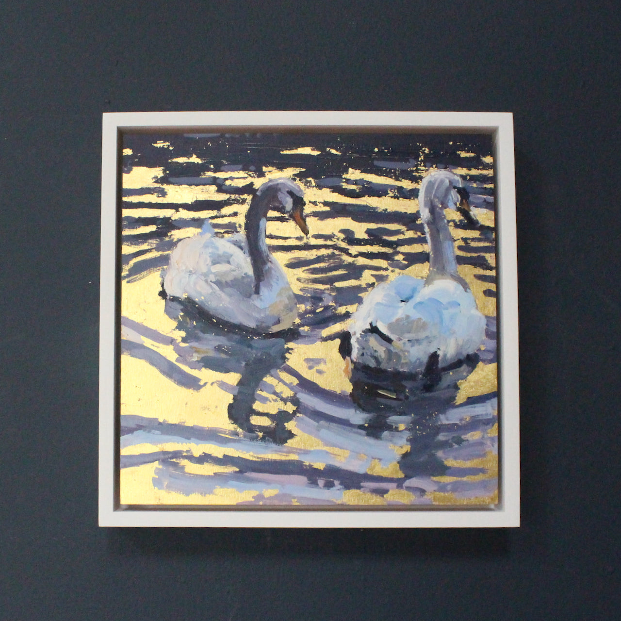 Artist Jill Hudson, two swans swimming on gold reflection water