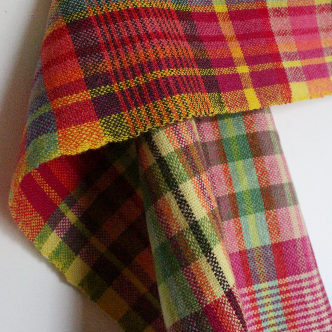 close up detail of a woollen hand-woven scarf in pinks, yellow and black by textile artist Teresa Dunne.