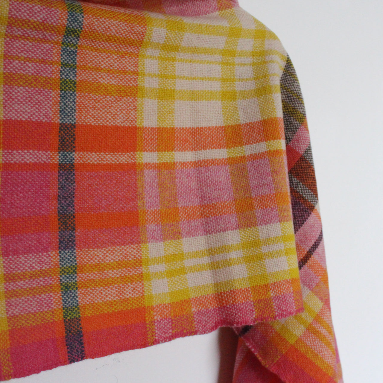 A handwoven woollen scarf by Teresa Dunne Cornish weaver in pink, cream, orange and yellow