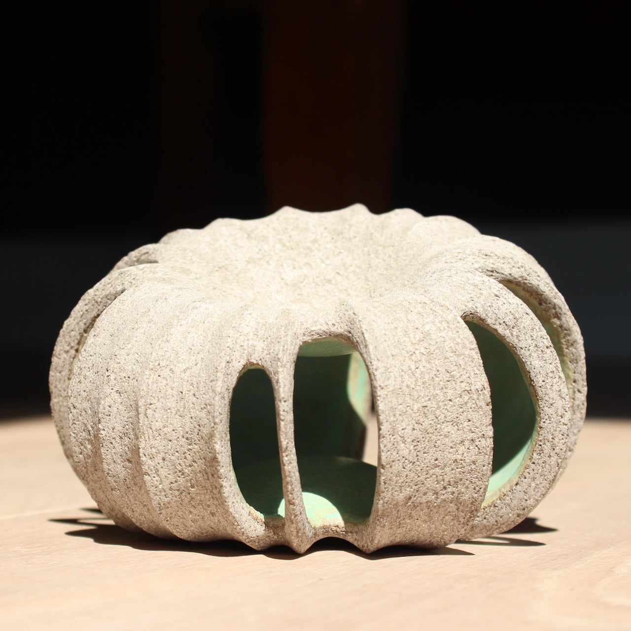 small rounded stoneware sculpture hand carved with a pale green interior glaze by UK ceramic artist Michele Bianco 