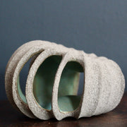 small rounded stoneware sculpture hand carved with a pale green interior glaze by ceramic artist Michele Bianco.