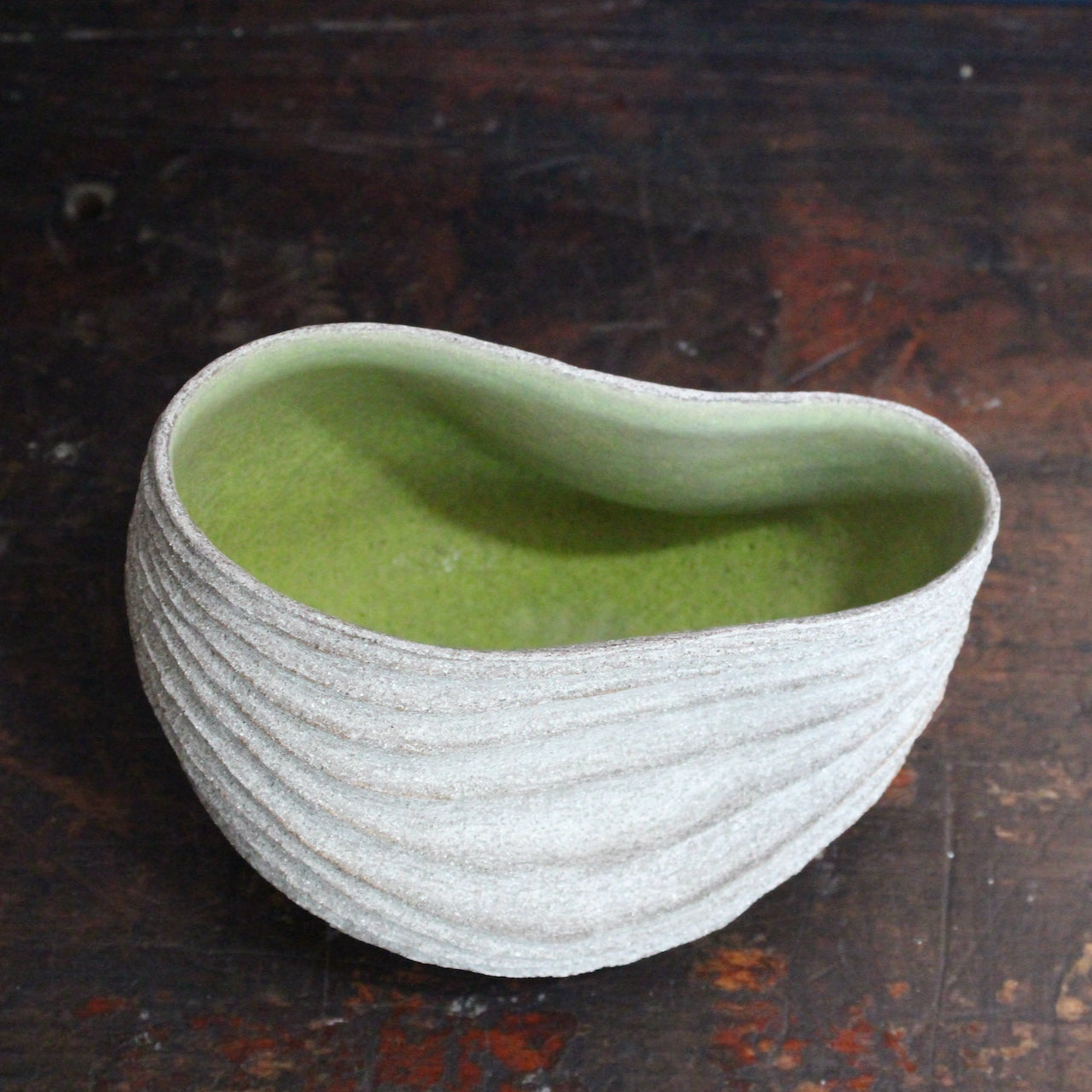 slumped carved with rib design stoneware bowl with a lime green interior glaze by UK ceramic artist Michele Bianco