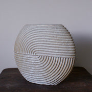 A large white  stoneware ceramic disc shaped vessel with carving detail by Michele Bianco.