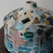 a squat pink and blue ceramic bottle by ceramicist Dawn Hajittofi.