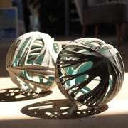 A pair of Michele Bianco carved and open round ceramic sculptures photographed in sunshine to show the shadow effect created