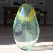 green and yellow glass vessel by glass artist Benjamin Lintell in the sunshine
