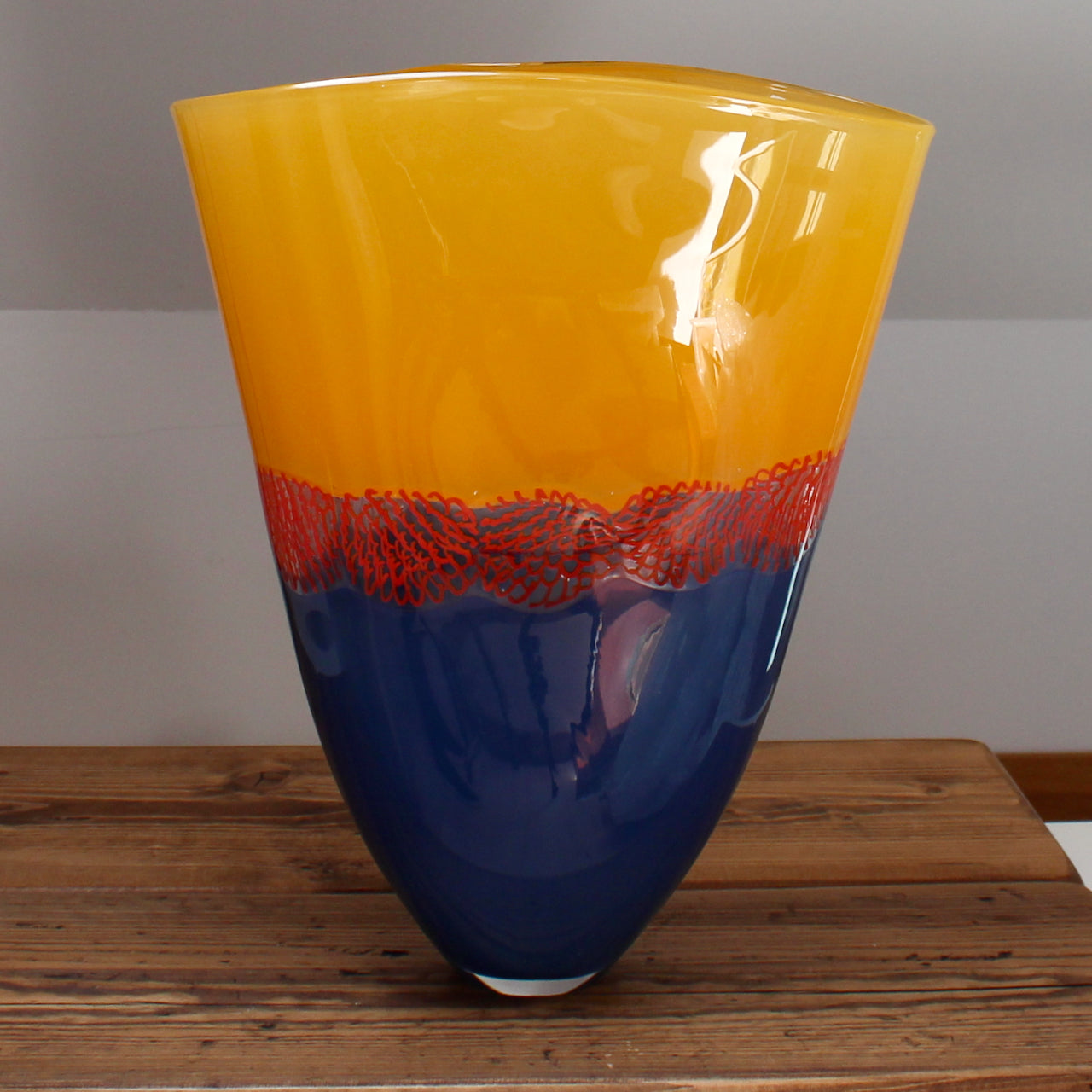 glass vessel by Benjamin Lintell with a blue base and orange top divided by a red detail at the Byre gallery