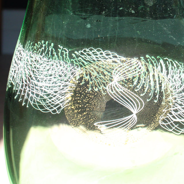 close up detail of green glass vessel with centre detail by Benjamin Lintell .