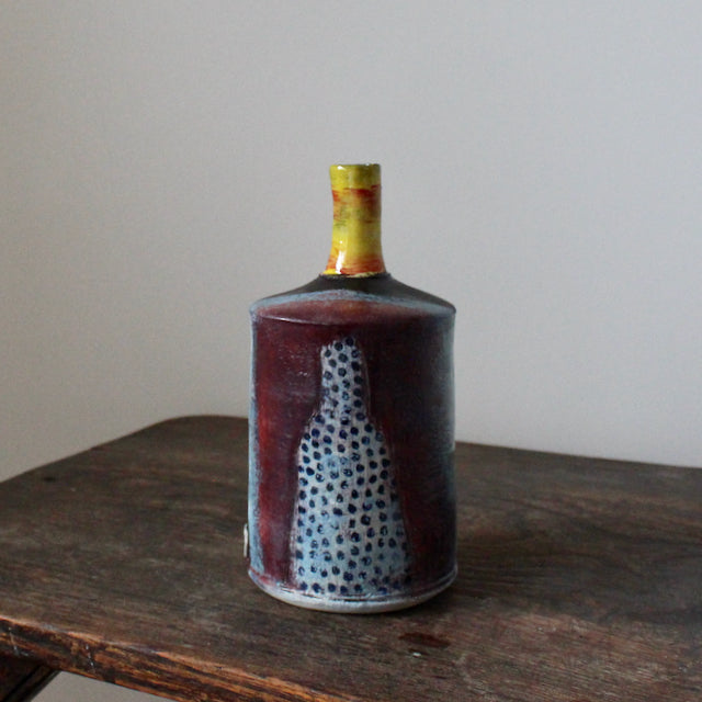 blue and red ceramic bottle with a yellow neck by John Pollex