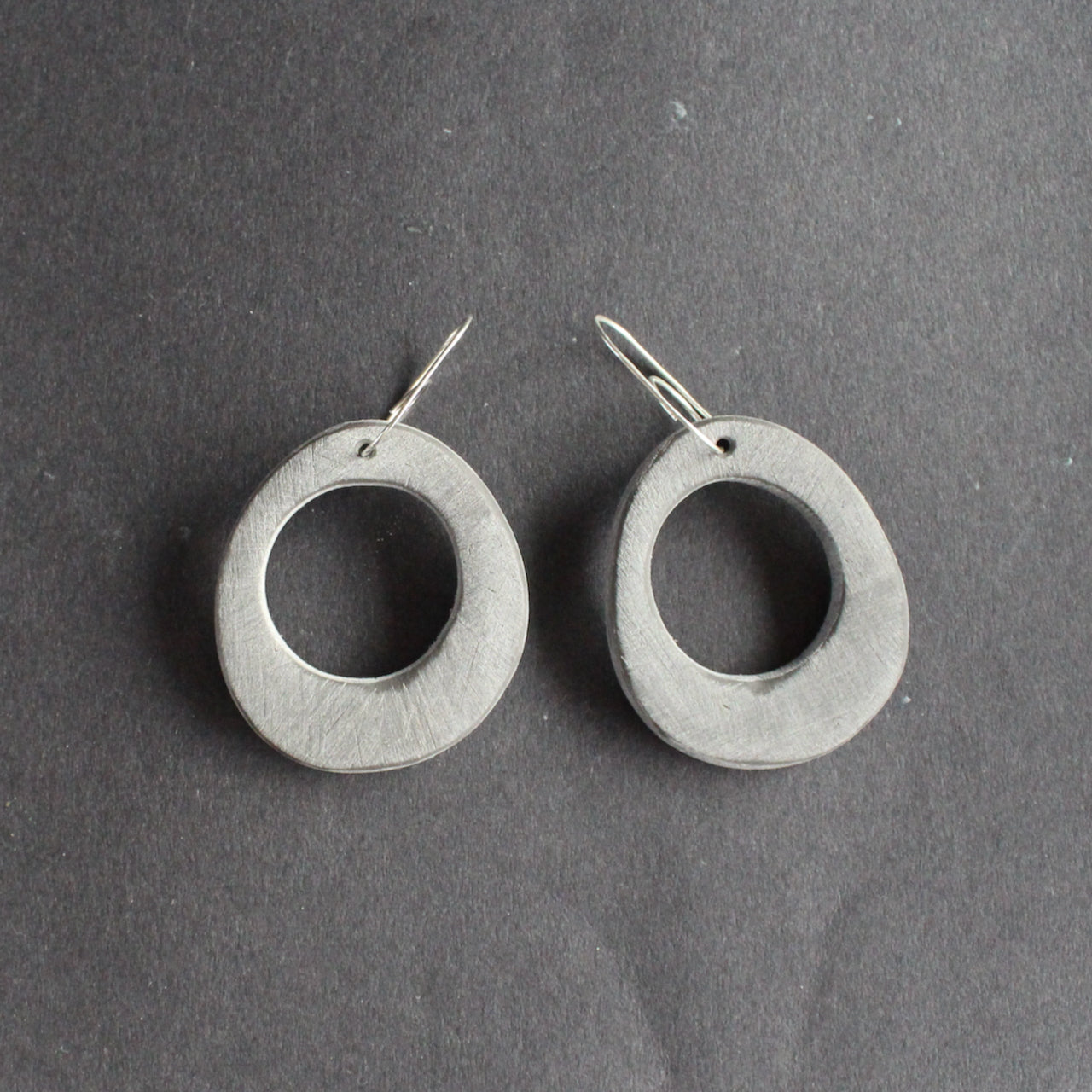 oval shaped pale grey earrings with hole in the middle  by UK jewellery designer Clare Lloyd