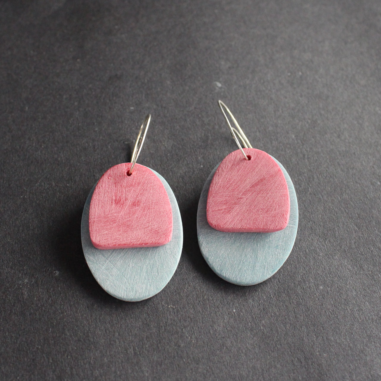 a pair of oval shaped earrings in pale blue and pink by jewellery designer Clare Lloyd