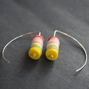 pair of earrings made of small discs on top of each other in yellow and shades of pink by UK jeweller Clare Lloyd