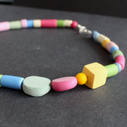 close up of necklace in different shaped beads in primary colours made by UK jewellery designer Clare Lloyd