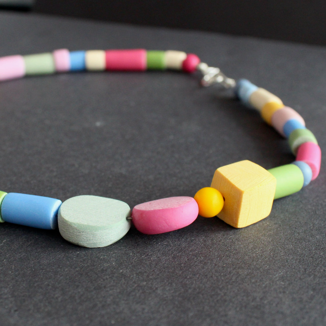 close up of necklace in different shaped beads in primary colours made by UK jewellery designer Clare Lloyd