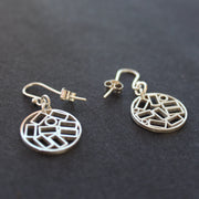 A pair of round silver drop earrings with cut out rectangles making the design at The Byre Gallery they are called Cambium drop earrings by Beverly Bartlett