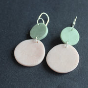 pair of earrings of a pink disc and smaller mint disc made by Clare Lloyd