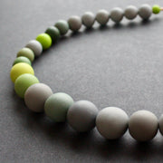 close up of a green and grey bead necklace by Clare Lloyd