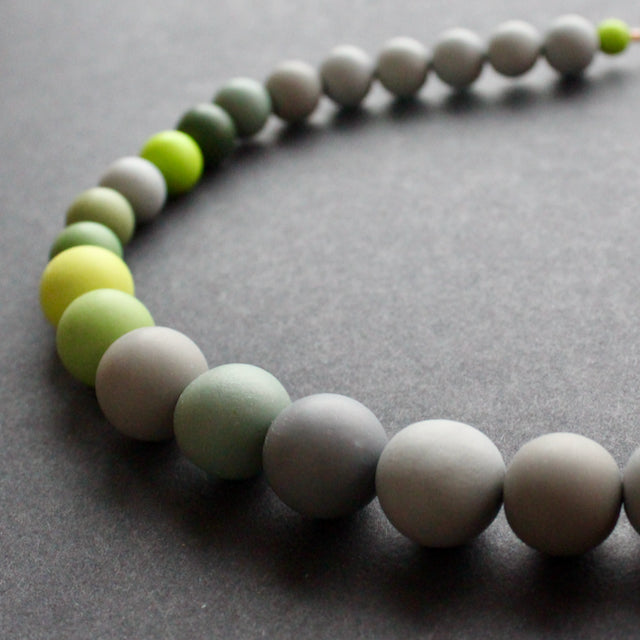 close up of a green and grey bead necklace by Clare Lloyd