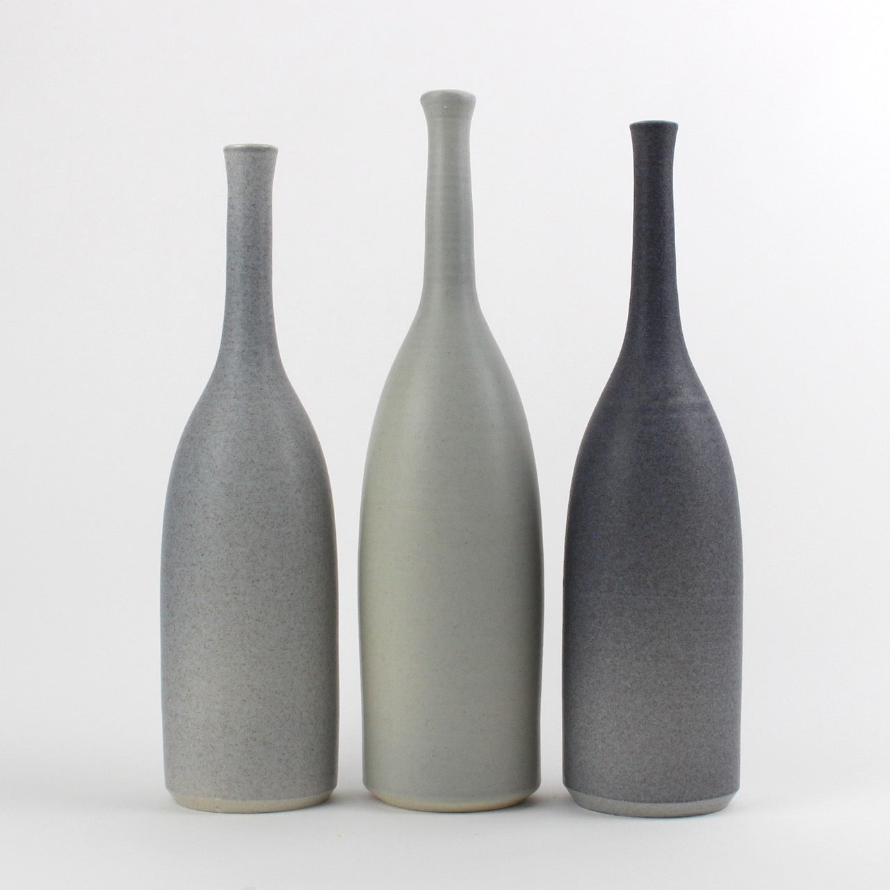 a trio of ceramic bottles in different shades of grey made by Lucy Burley