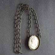 A cameo necklace made from blackened brass and cement by Amy Stringer