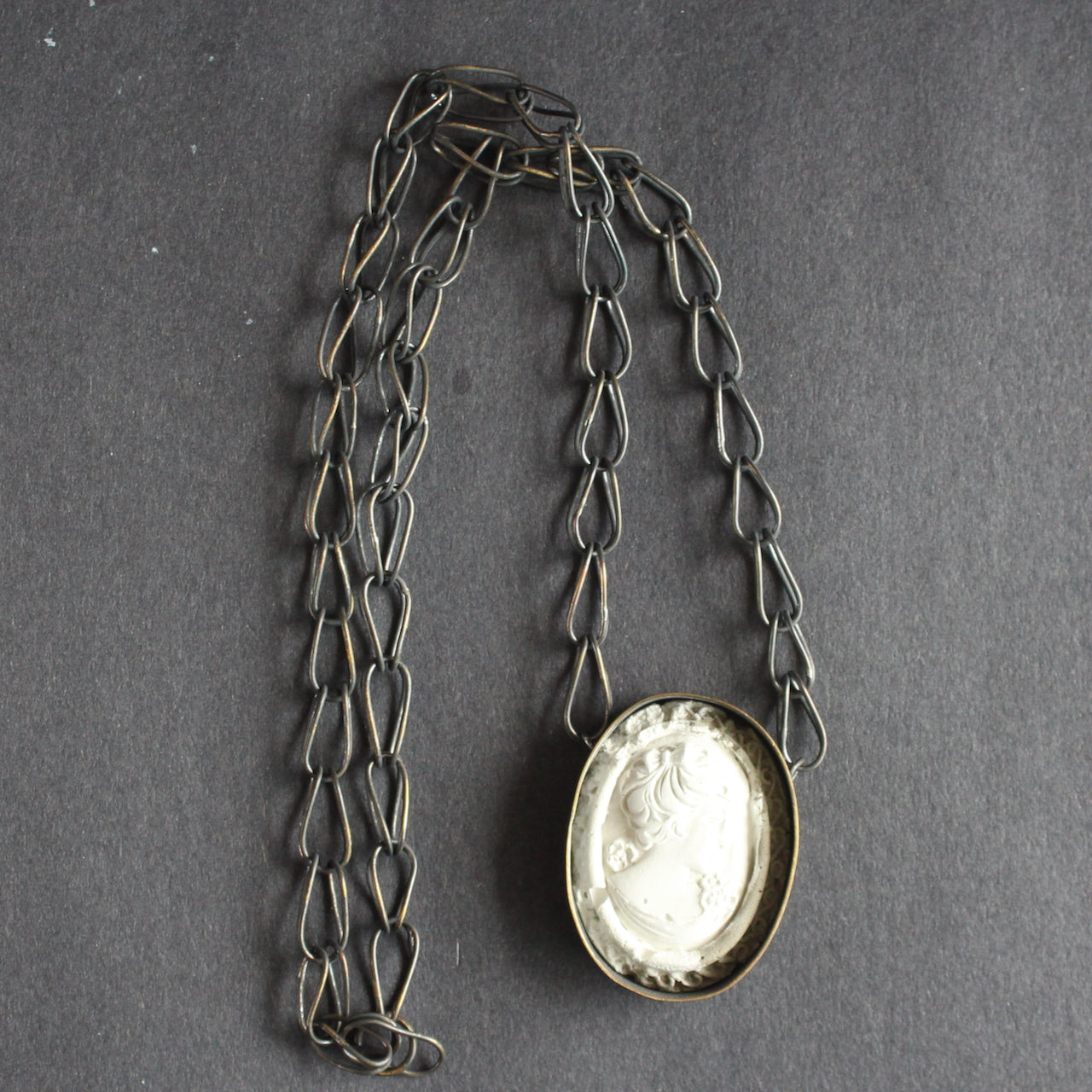 A cameo necklace made from blackened brass and cement by Amy Stringer