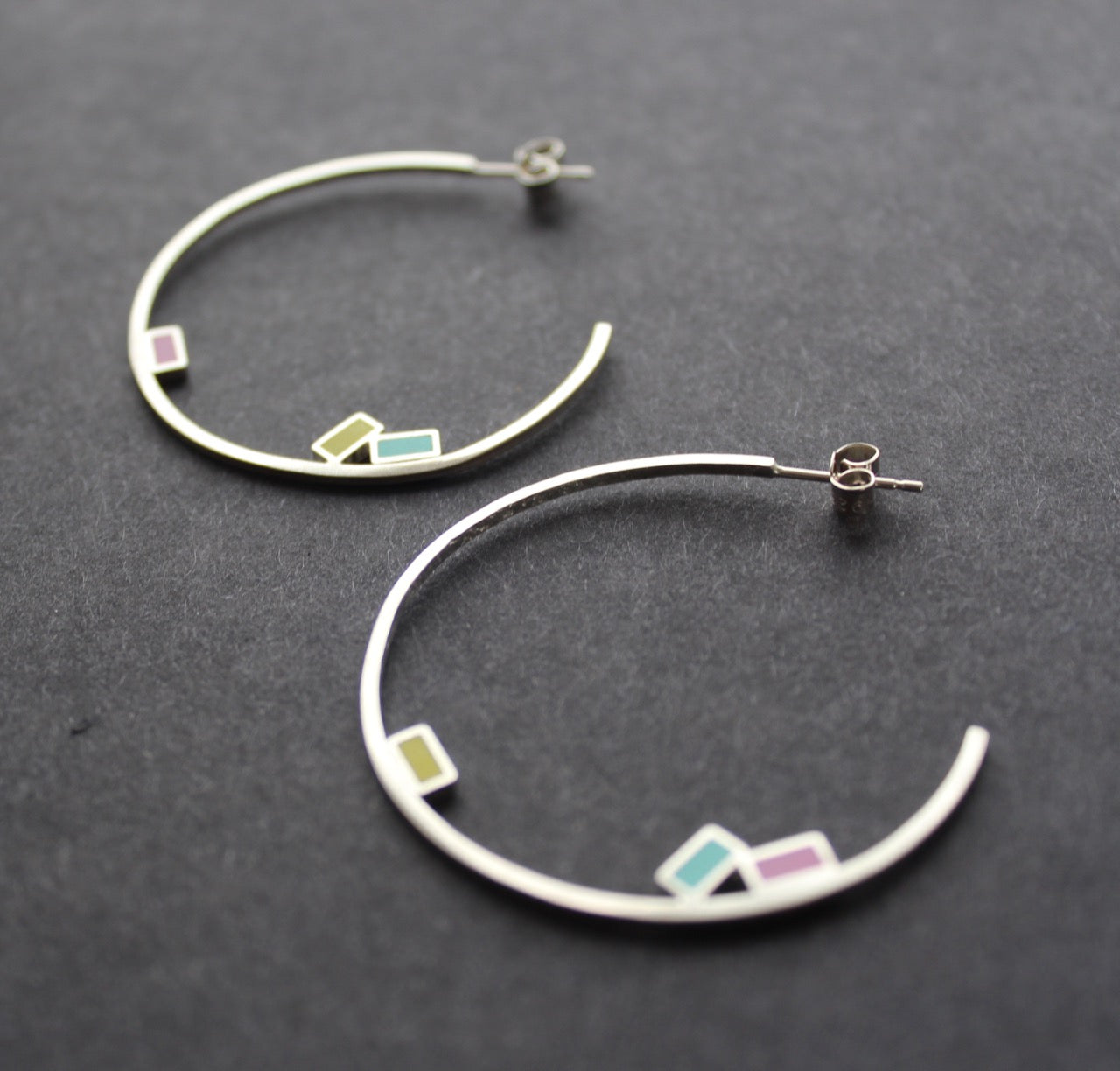 Abstract large rigid hoop earrings with small coloured squares by Clare Lloyd