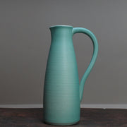 Duck egg ceramic jug with a handle by Lucy Burley on a wooden table at the Byre Gallery