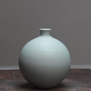 Light green round ceramic bottle by Lucy Burley, on a wooden table at the Byre Gallery