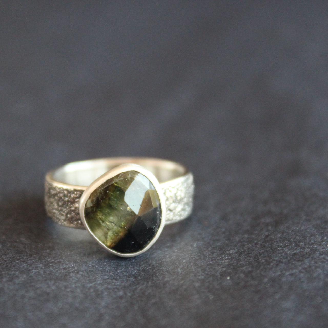 a textured silver ring with a dark green stone by UK jeweller Carin Lindberg