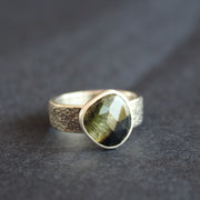 a textured silver ring with a dark green stone by Cornwall jeweller Carin Lindberg