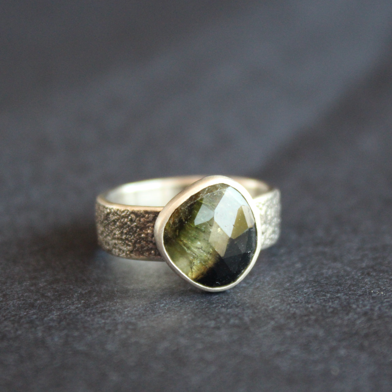a textured silver ring with a dark green stone by Cornwall jeweller Carin Lindberg